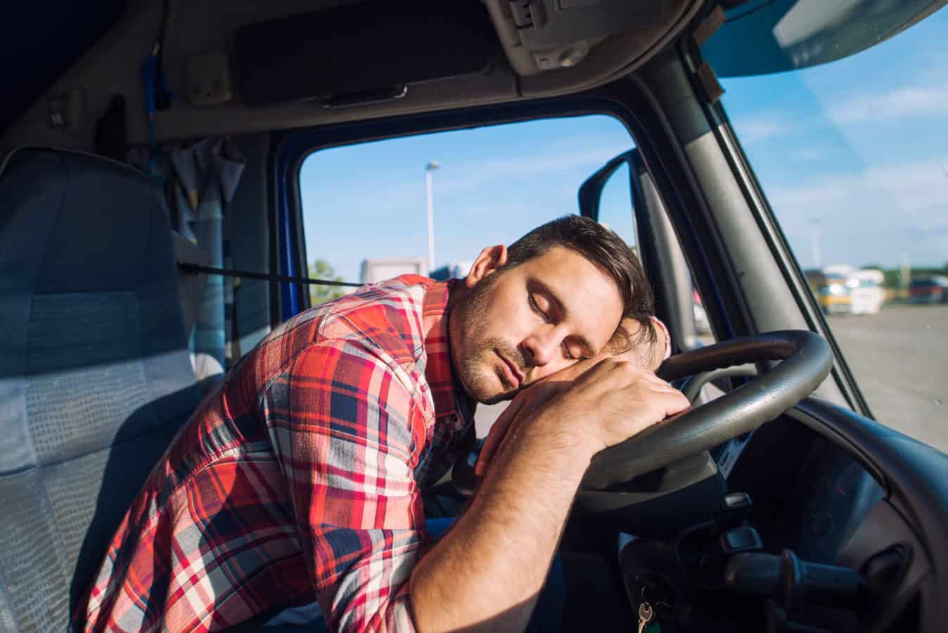 Man sleeps on steering wheel of RV in parking lot