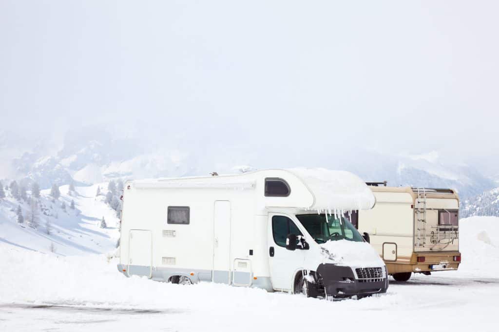 Class B motorhome covered with snow and ice.