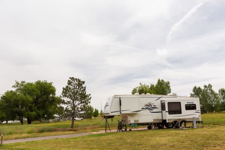 5th wheel parked and connected at an RV campsite.