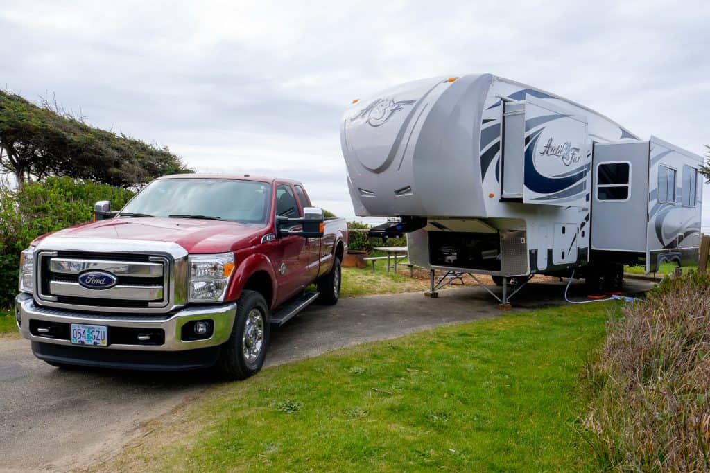 Red pickup getting set to connect 5th wheel camper.