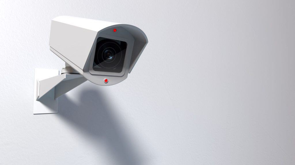 Activated security camera on white background.
