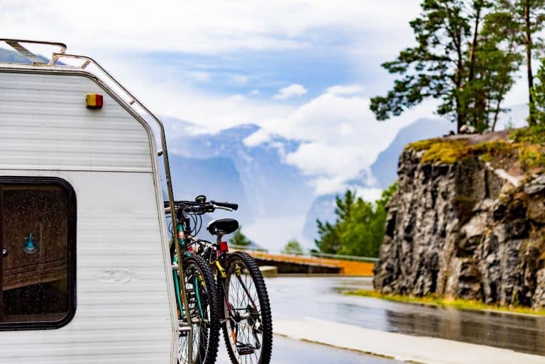Bicycles attached to the side of a travel trailer.
