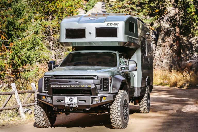 Overland vehicle with truck-bed camper attached.