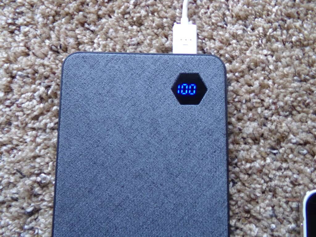 A portable power bank shows battery life via a digital readout.