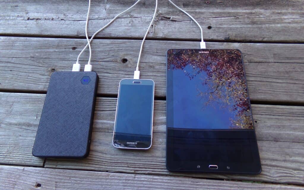 3 mobile devices plugged into charging cables.