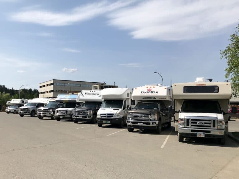 Row of RVs in parking lot.