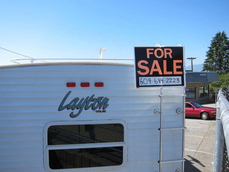 Back of travel trailer with For Sale sign attached.