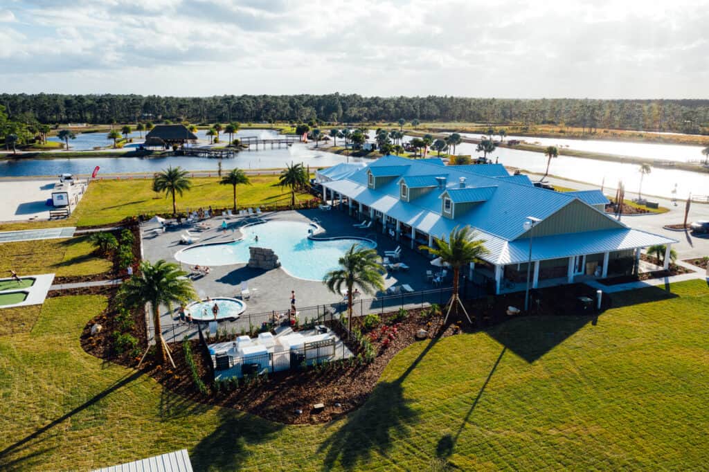 Aerial view of luxury RV resort in Florida amidst lakes and pool.