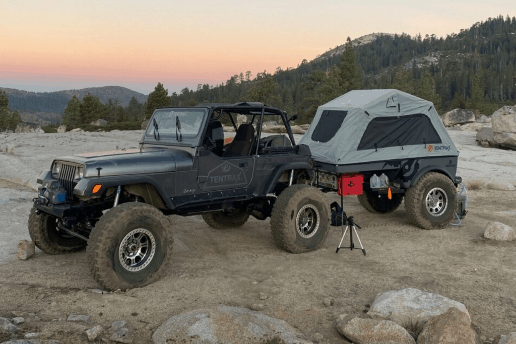 Jeep with a Tentrax four wheel camper on rugged terrain.