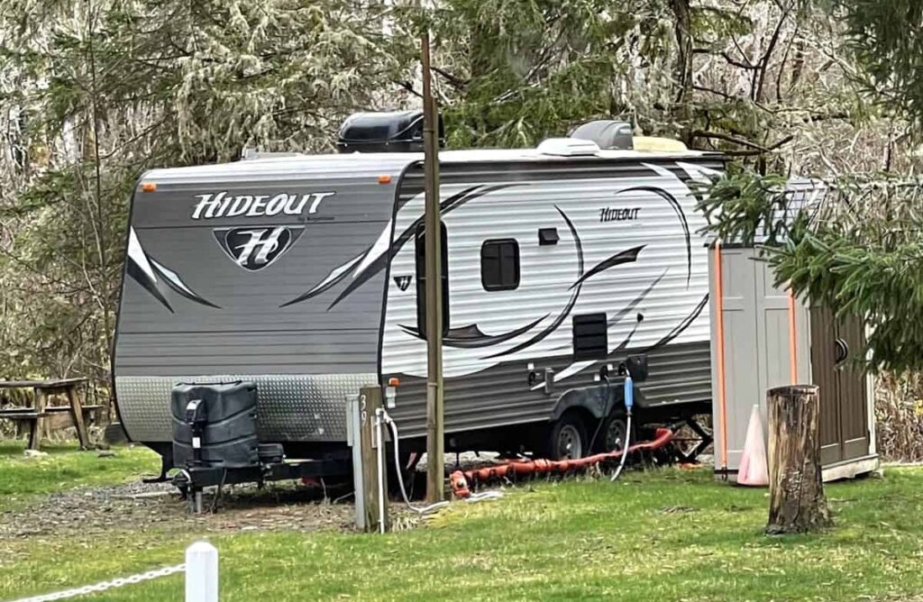 Travel trailer set up in an RV park with unattached storage shed