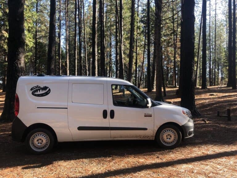 white RAM ProMaster City cargo van with Cascade Campers logo parked in the woods