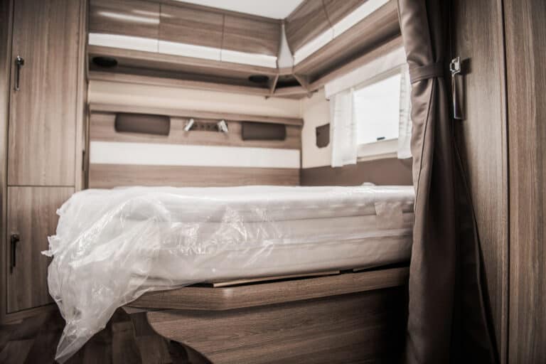 An RV mattress in the corner of a travel trailer.