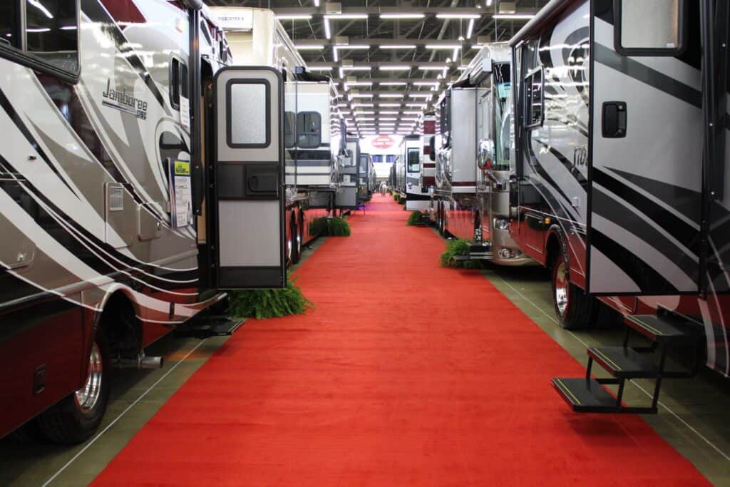 Red carpet between setup RVs in an expo center