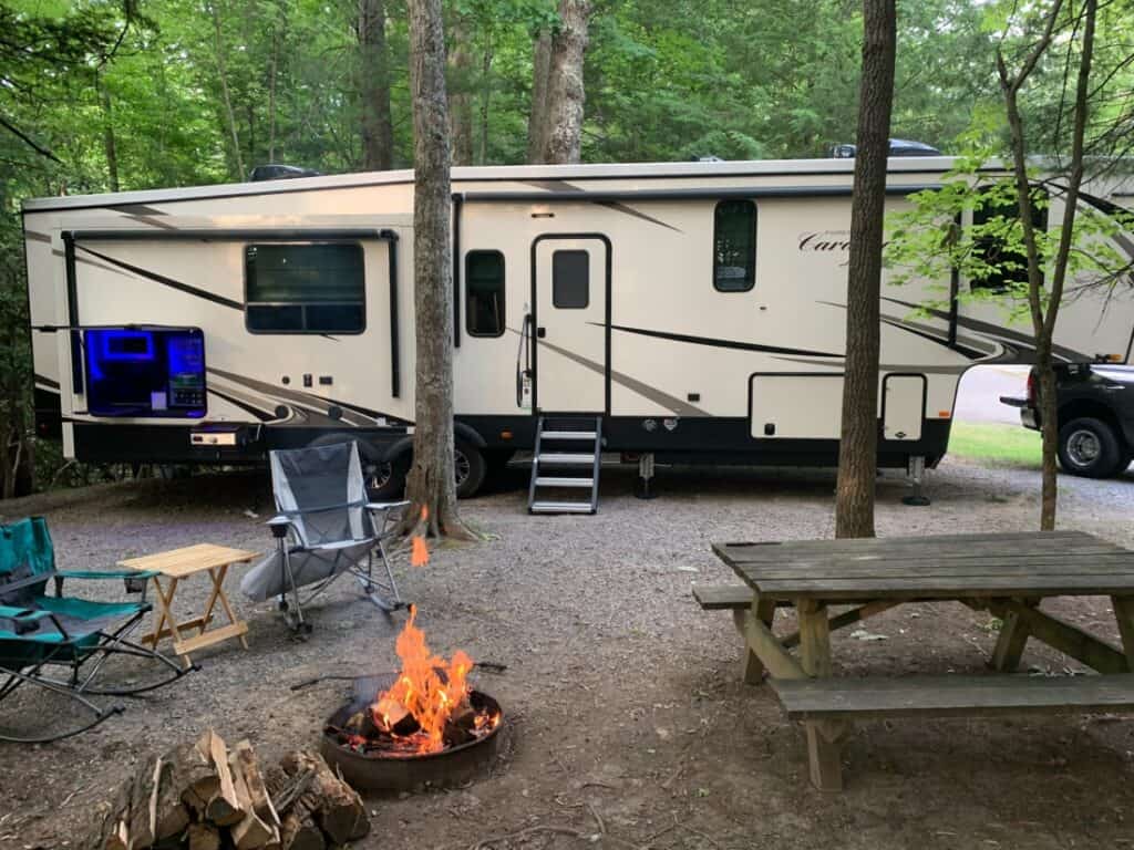 RV set up with a fire pit, picnic table, and camping chairs in Little Beaver State Park - average RV campsite cost