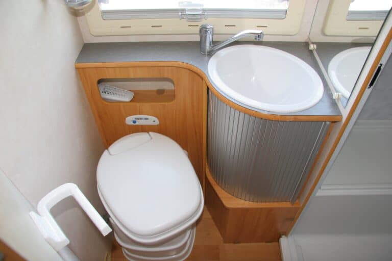 view of toilet and sink in an RV - Feature photo for RV Wet Baths vs RV Dry Baths: