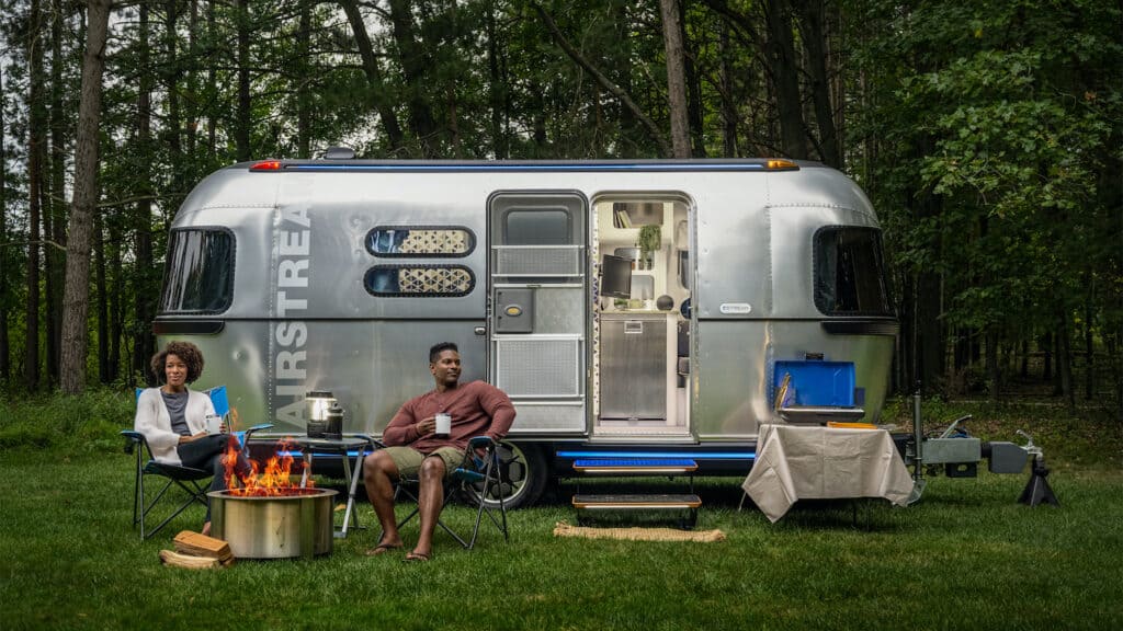 Couple sits outside their Airstream eStream