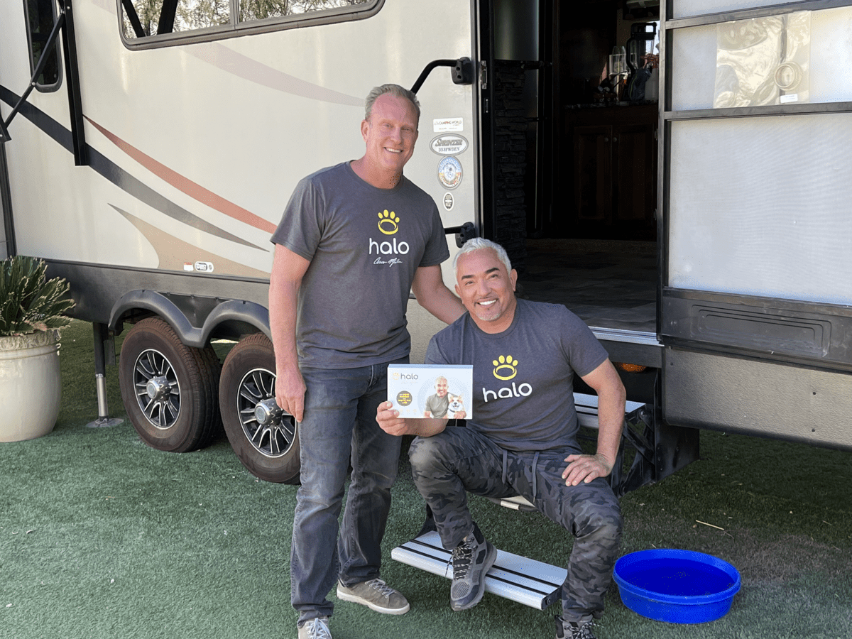 Cesar Millan and Ken Ehrman show the Halo Collar in front of an RV