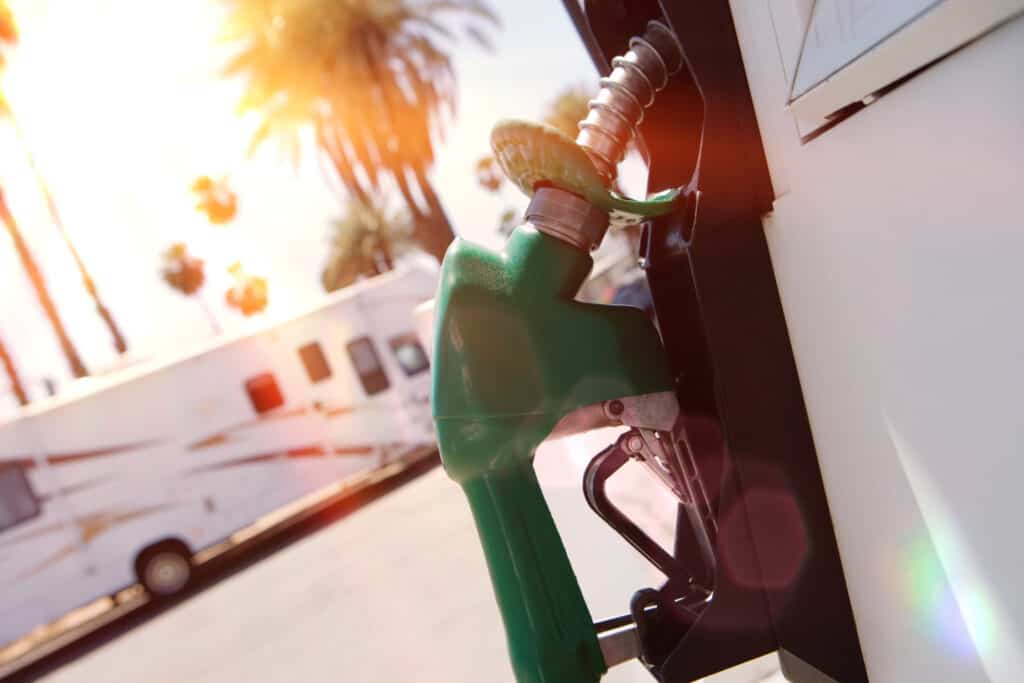 gas pump at station with RV in background - feature image for Gas Credit Cards For RVers