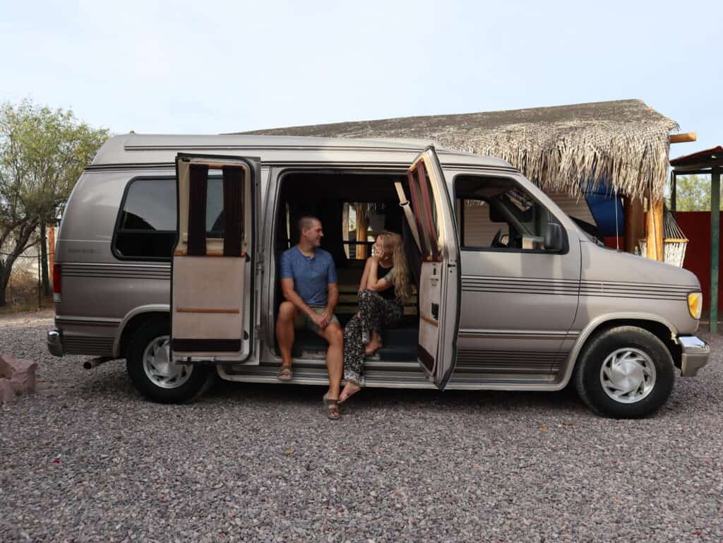 Kendall & Jennifer Jennings, founders of RVSpotDrop, sit together in an open camper van.