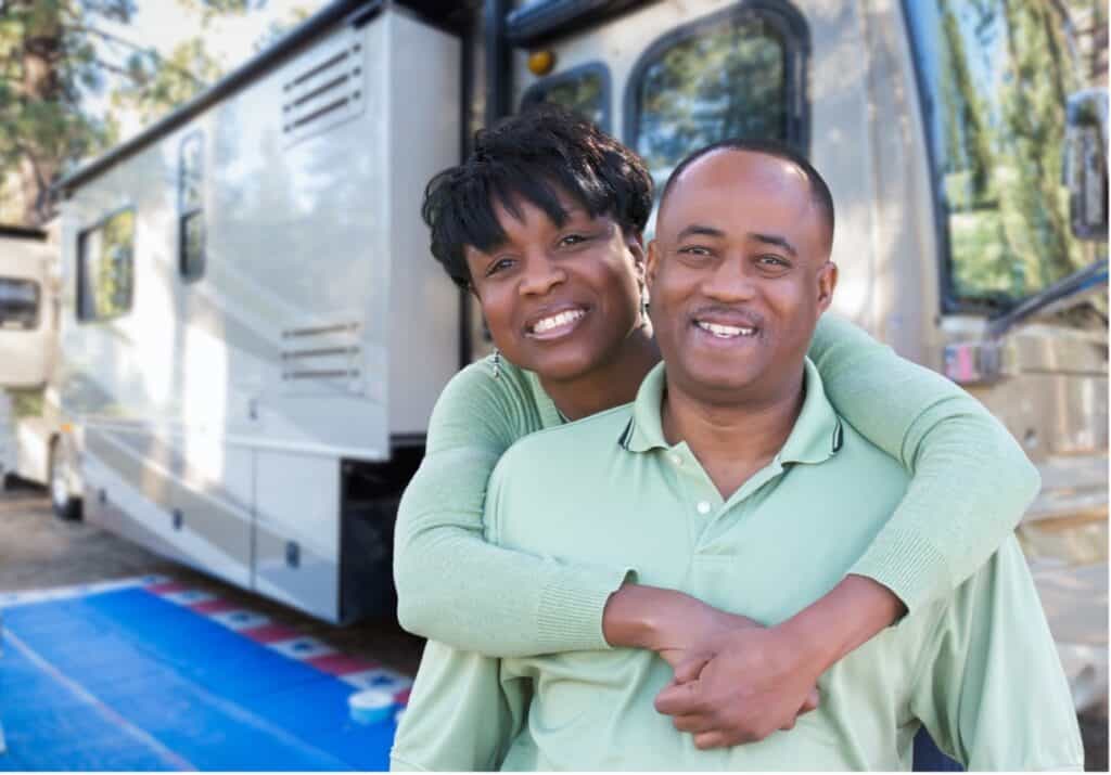 Info the RV industry analysis shows that millions of people like this couple hugging outside of an RV enjoy this type of recreation.