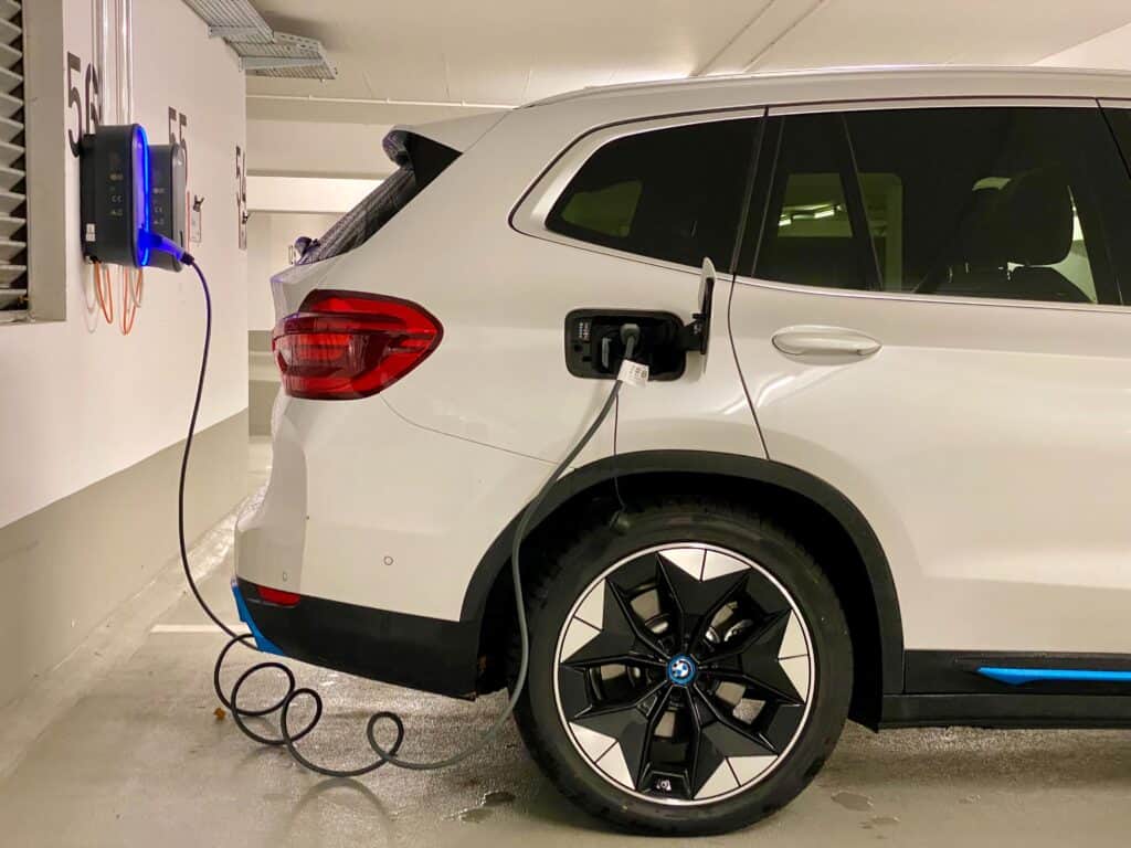 A small electric SUV charges in a parking garage.