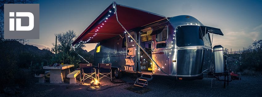 Airstream trailer setup at night at a campsite.