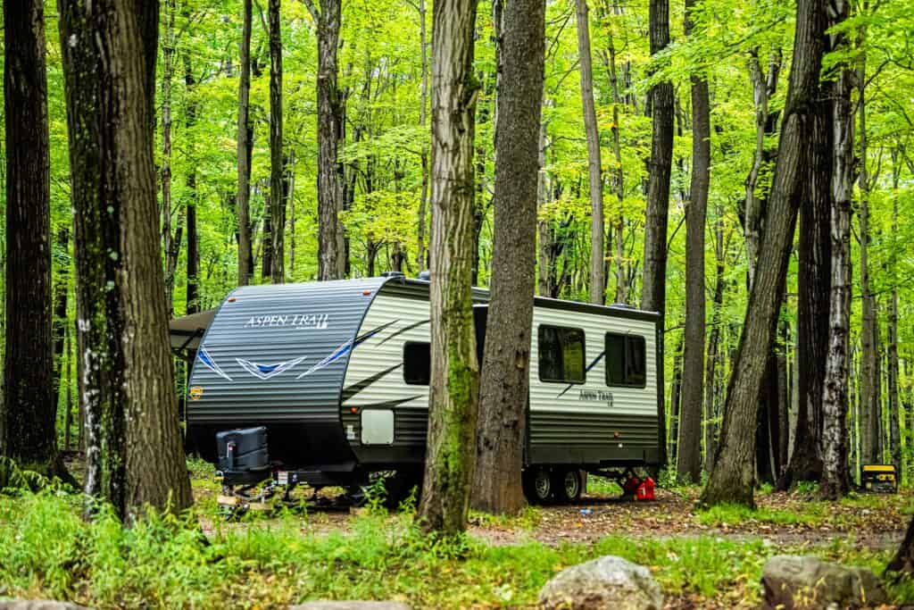 trailer in the woods - feature image for private RV parks near national parks