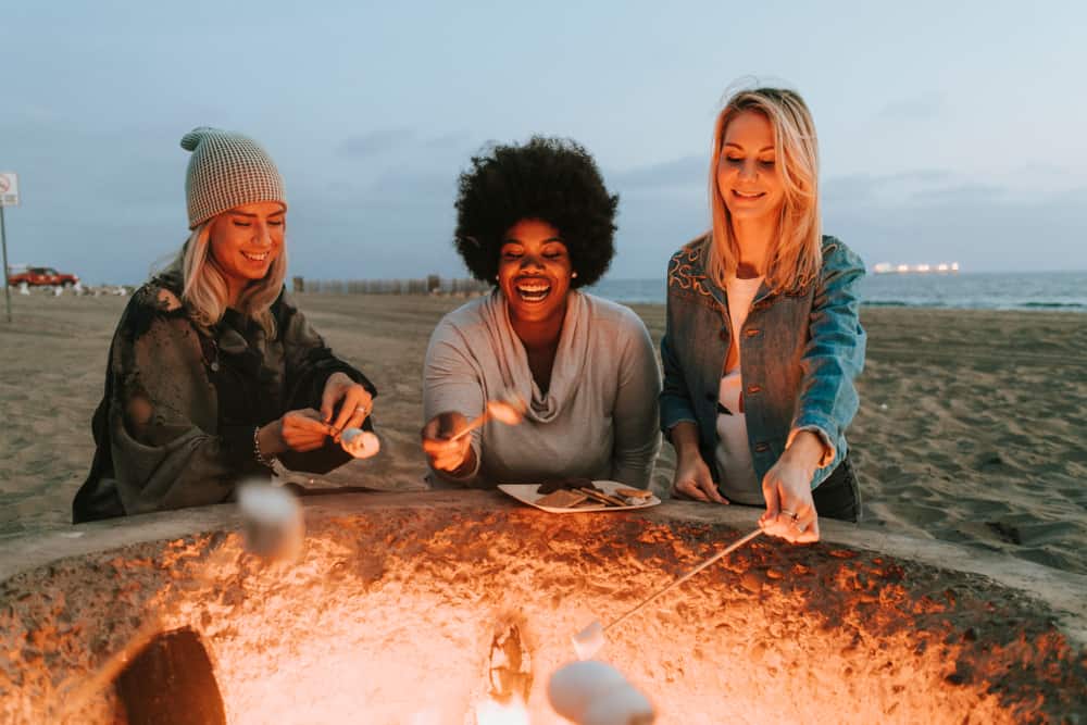women RVers sitting around a campfire