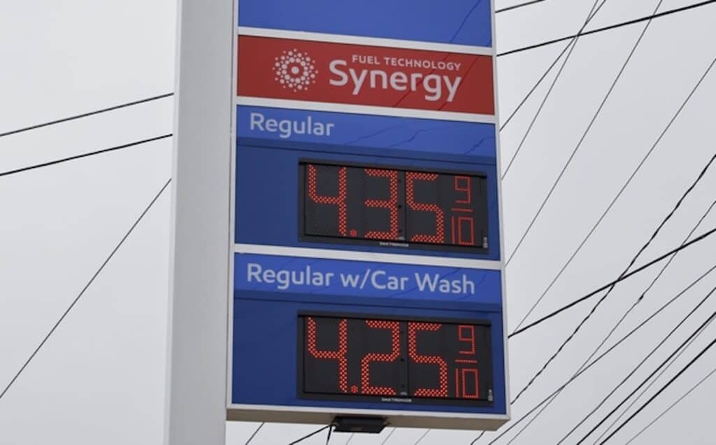 gas prices on signboard against gray sky