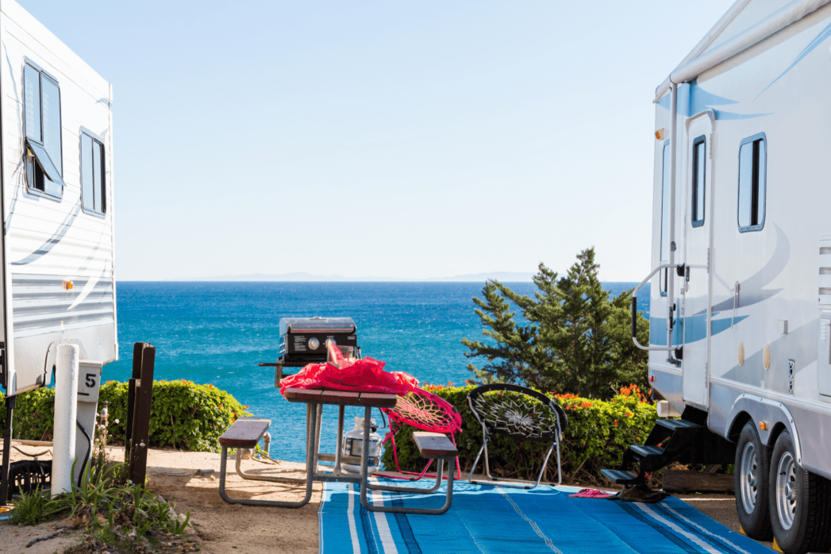 Two RVs parked in front of the ocean