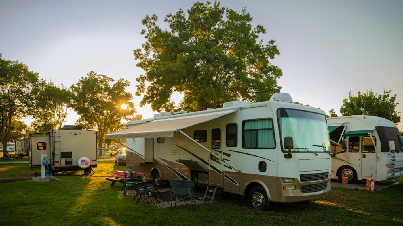 Sun going down at the Rv park with lights on the motor home - feature image for travel trends