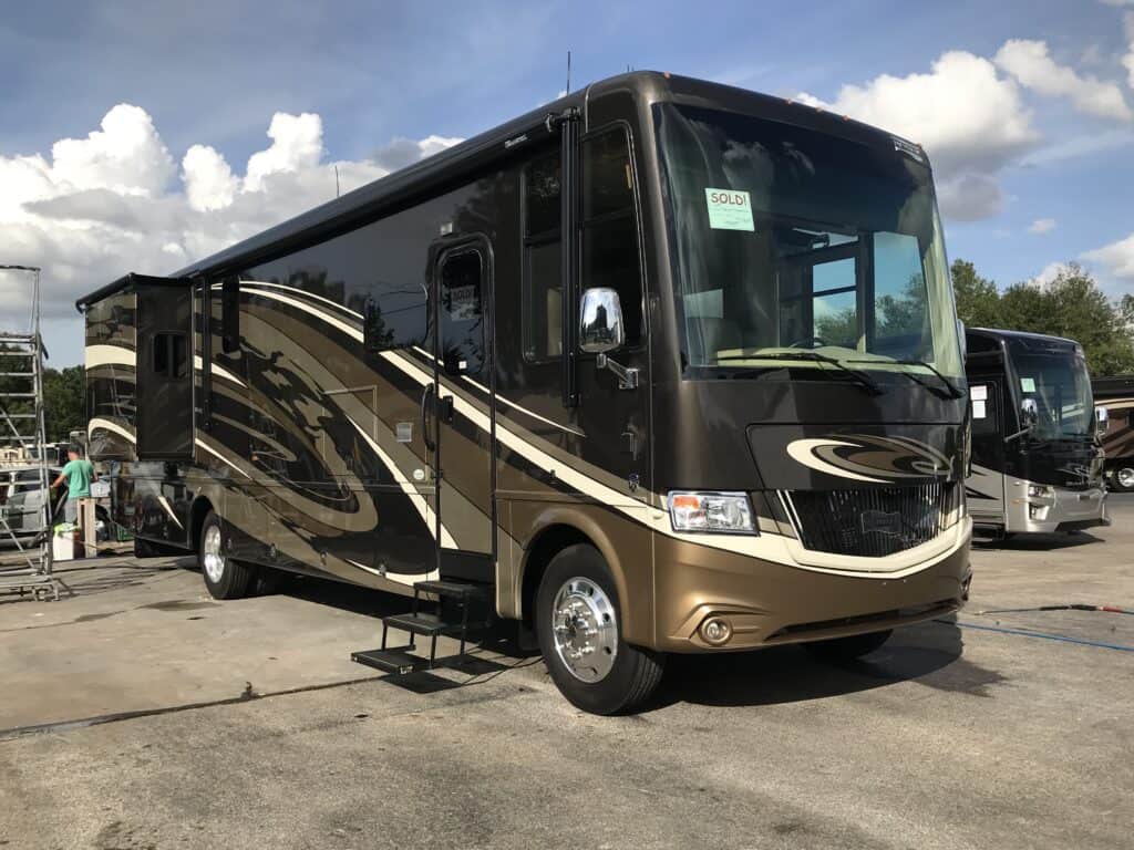 a brand new dark brown Newmar RV on the sales lot