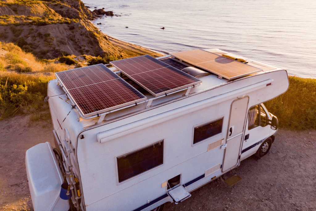 RV parked beside the ocean with solar panels on the roof - solar options