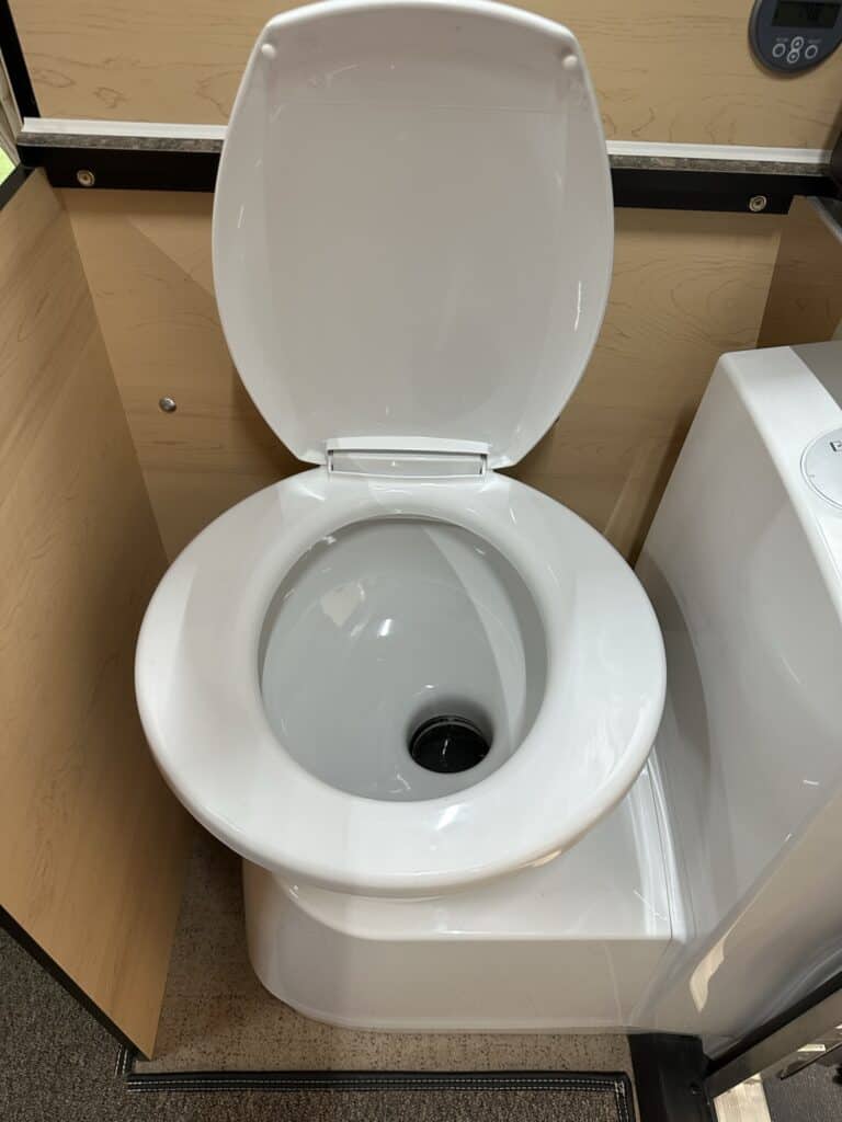 An RV toilet with an open lid.
