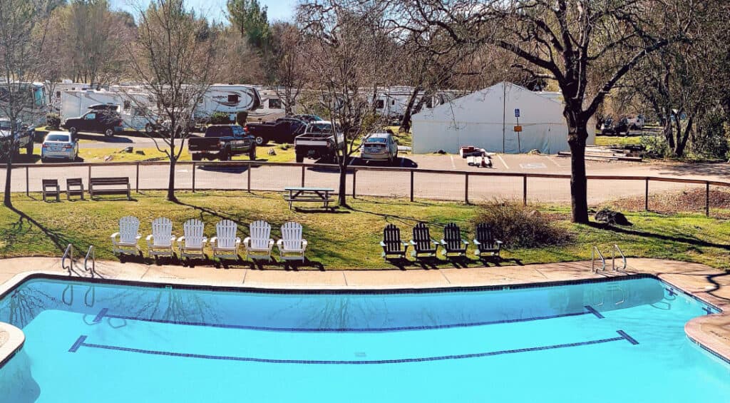 Pool with chairs and rvs camping at Placerville RV Resort & Campground