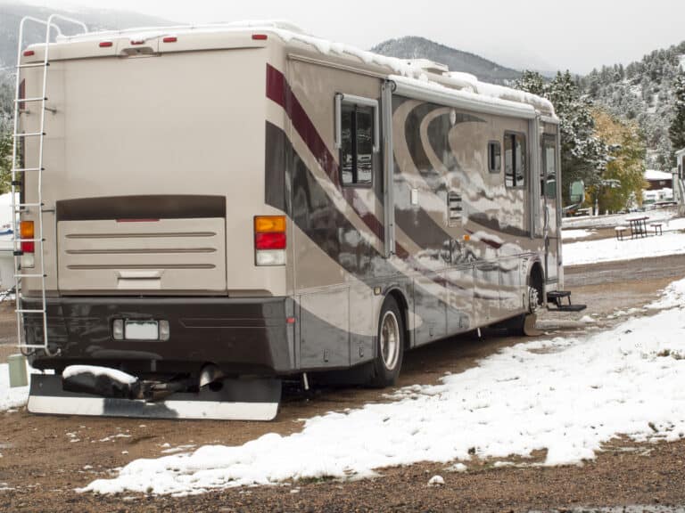 Class A motorhome parked in a snowy campsite.