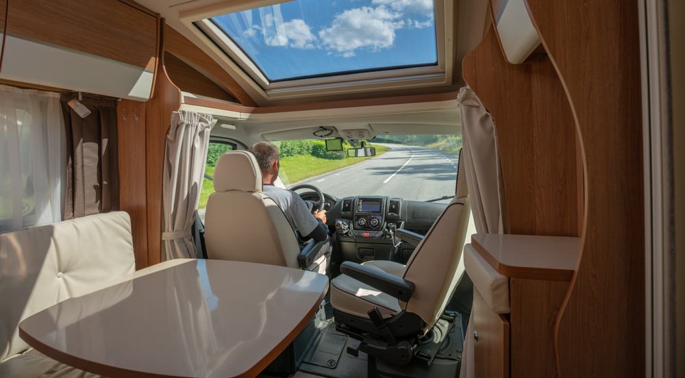 Interior view of a Class B camper van with man behind the wheel.