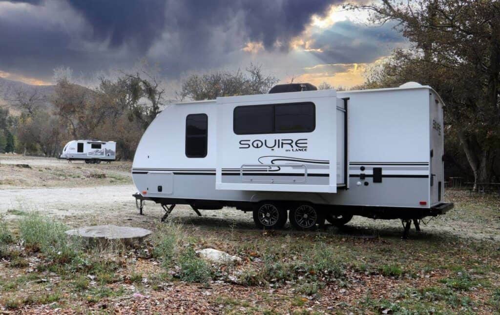 Squire travel trailer parked in a rustic campsite.
