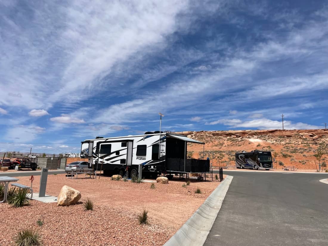 A fifth-wheel in an RV site at Roam America Horseshoe Bend, with a motorhome in the background.