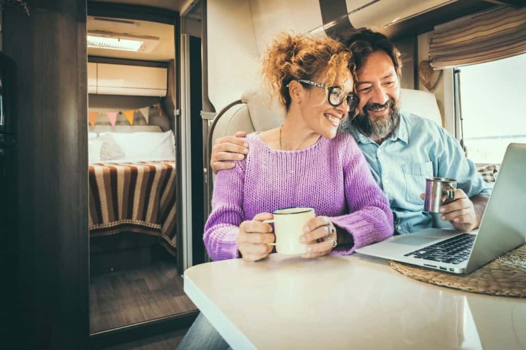 Happy couple in front of a laptop buying an RV online.