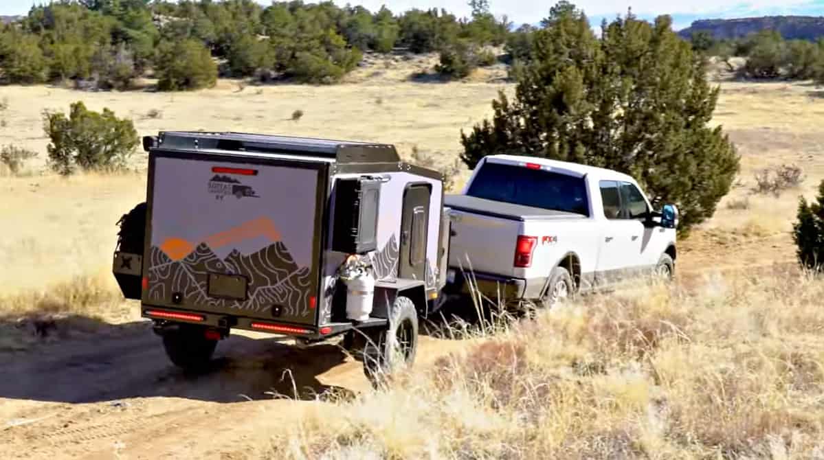 White truck towing a Boreas XT off-road trailer in a remote location. Photo: Boreas Campers.
