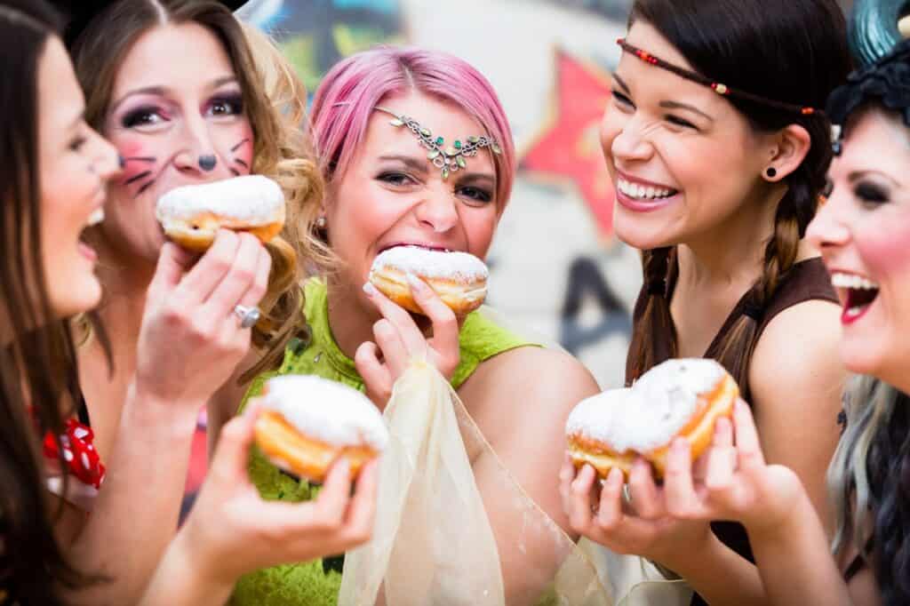 Girls eating snacks at Mardi Gras.